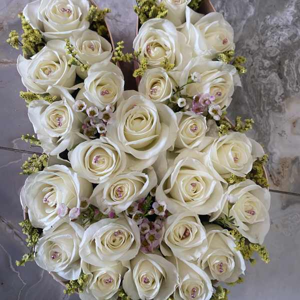 Round bouquet of white roses with small pink filler flowers