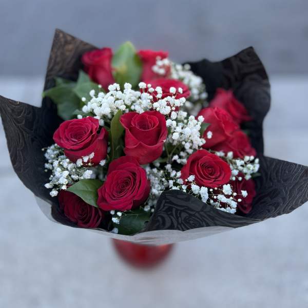 Bouquet of red roses with white baby's breath in black wrap