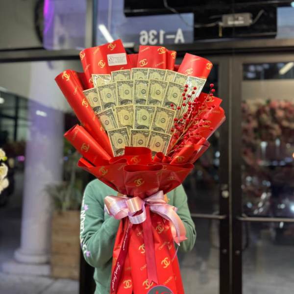 Bouquet of folded dollar bills wrapped in red paper with a ribbon