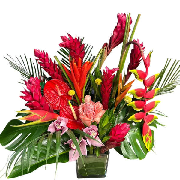 Tropical bouquet with red and pink flowers in a square glass vase