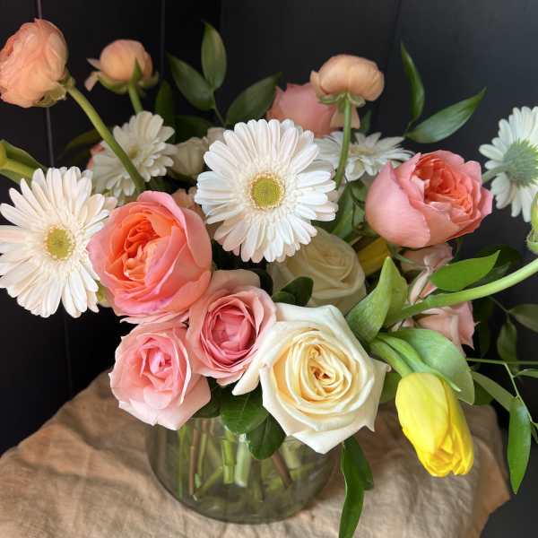 Pink and white roses with white daisies in a glass vase