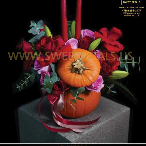 Pumpkin centerpiece with red roses and two tall red candles