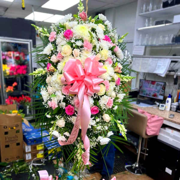 Large pink and white floral standing spray with a pink bow