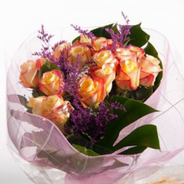 Bouquet of peach and yellow roses with purple filler flowers