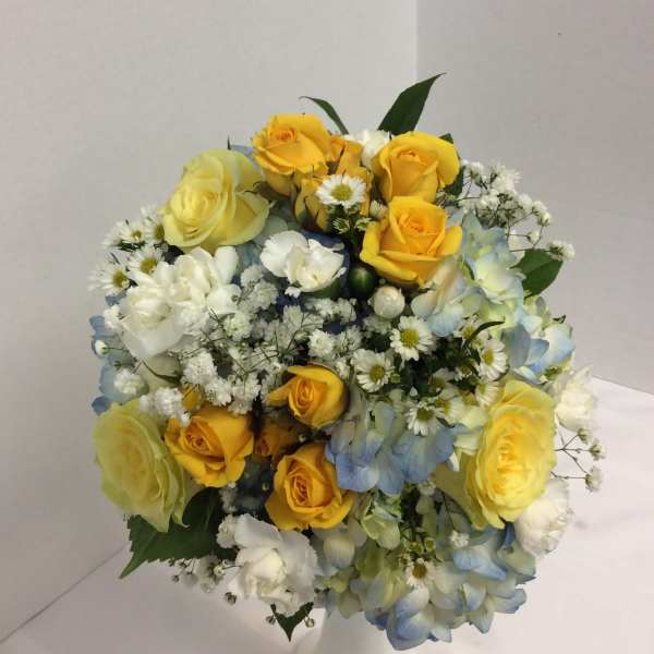 Bouquet of yellow roses, blue hydrangeas, and white filler flowers