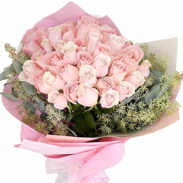 Bouquet of pale pink roses wrapped in pink paper