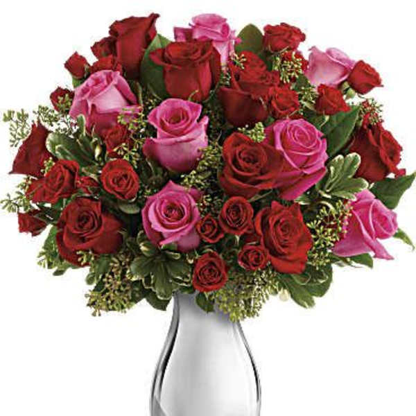 Bouquet of red and pink roses in a clear glass vase