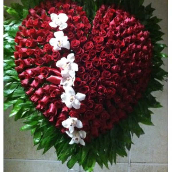 Heart-shaped red rose arrangement with white orchids and green foliage