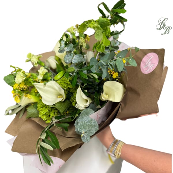 Bouquet with white calla lilies and green flowers wrapped in brown paper