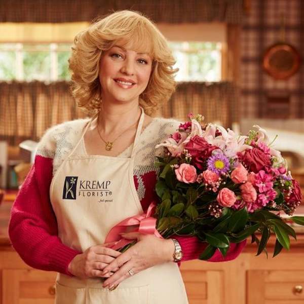 Woman holding a pink mixed flower bouquet with roses and lilies