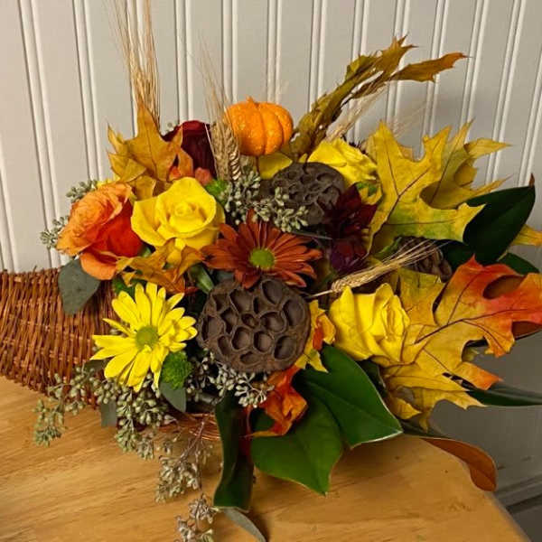 Autumn bouquet with yellow and orange flowers in a wicker cone