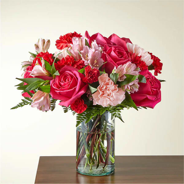 Pink roses and carnations in a clear glass vase