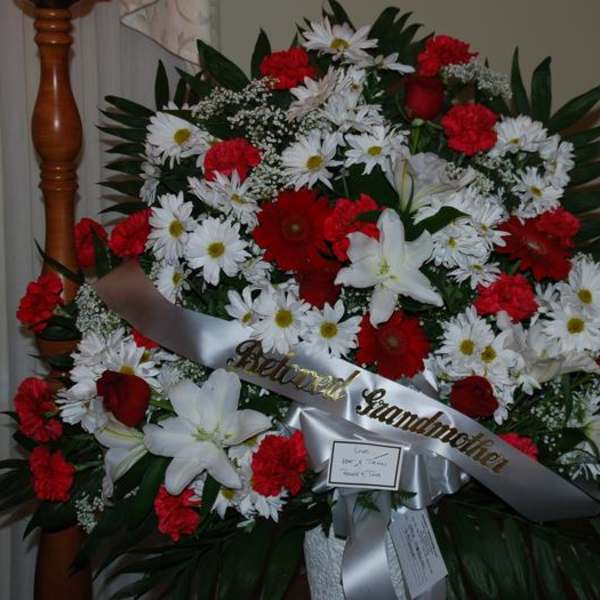 Large red and white funeral spray with a memorial ribbon