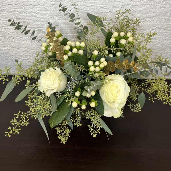 White roses with berries and eucalyptus in a low arrangement