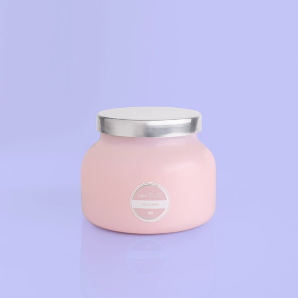Pink jar candle with a silver lid on a lavender background