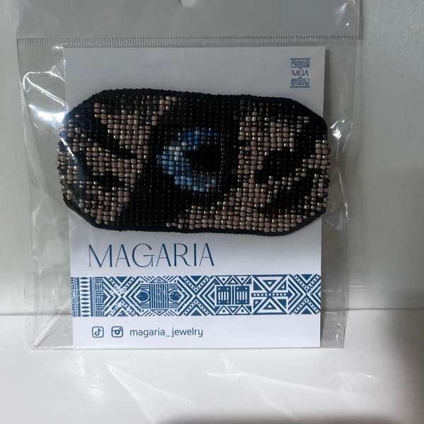 Beaded black hair accessory in plastic packaging