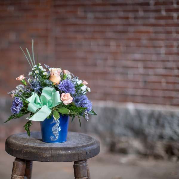 Mixed bouquet in a blue vase with a mint ribbon bow