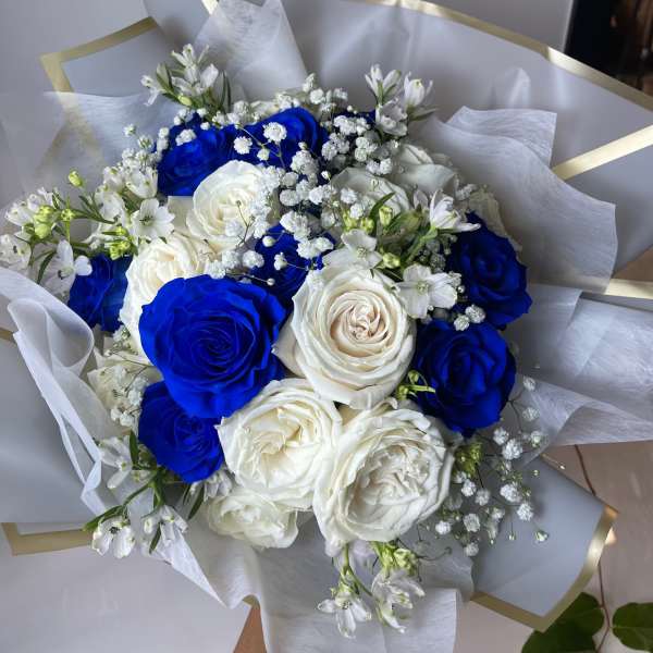 Bouquet of blue and white roses with small white filler flowers