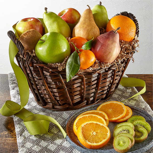 Basket of assorted fruit with oranges and kiwi slices on a table