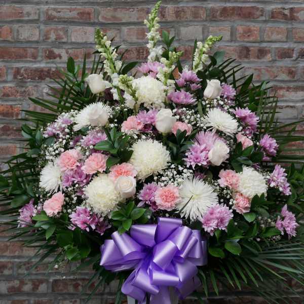 Large pink and white floral spray with a purple ribbon bow