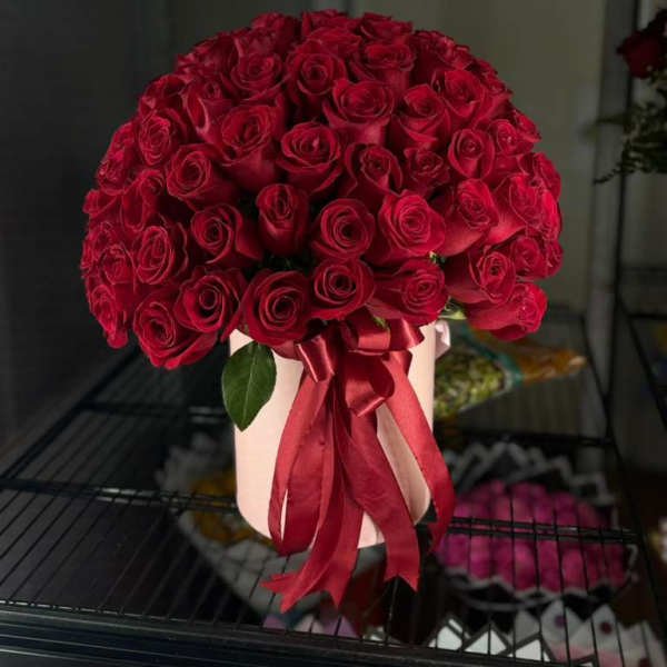 Large bouquet of red roses tied with a satin ribbon in a pale box