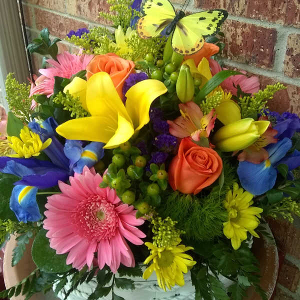 Colorful mixed bouquet with roses, lilies, daisies, and a butterfly pick