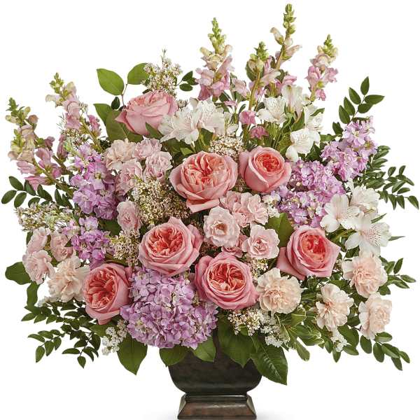 Pink roses and mixed blooms arranged in a dark vase