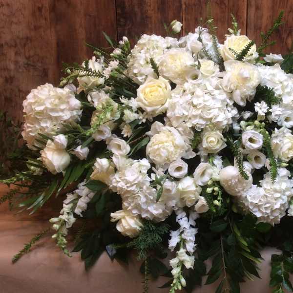 Large white floral arrangement with roses and hydrangeas