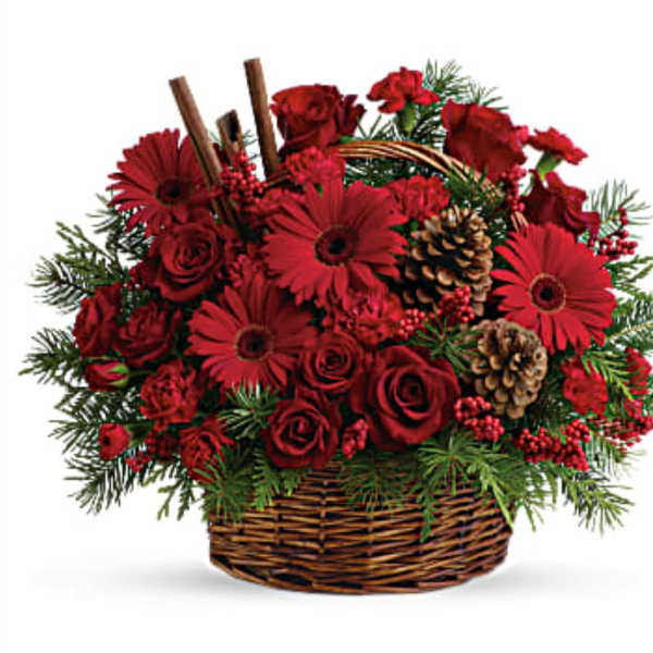 Red roses and gerbera daisies in a wicker basket with pinecones