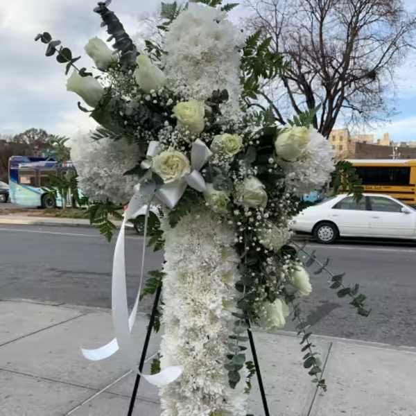 Tall white floral standing spray on an easel with ribbon