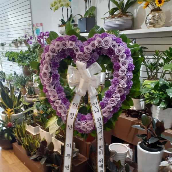 Purple heart-shaped floral wreath with ribbon streamers
