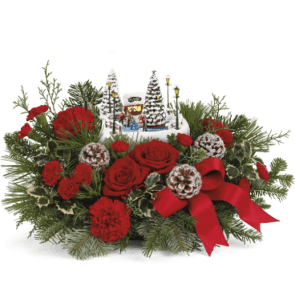 Red roses and carnations with a Christmas village centerpiece