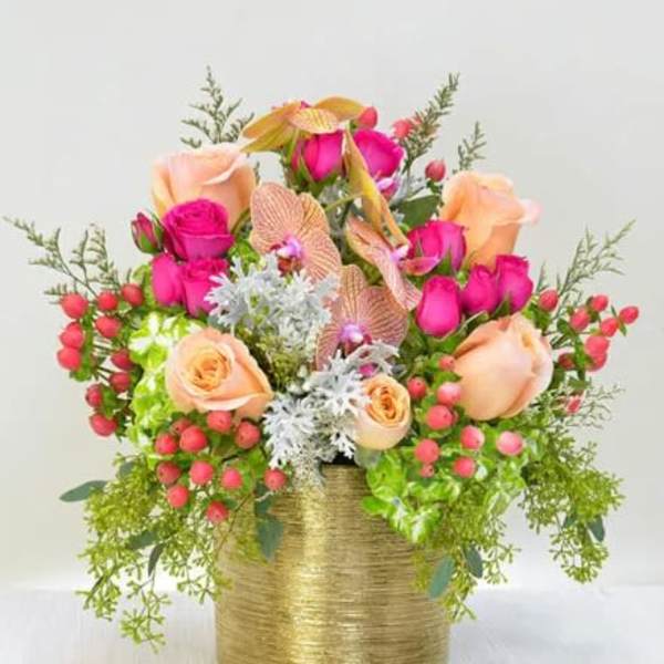Pink and peach roses arranged in a gold vase