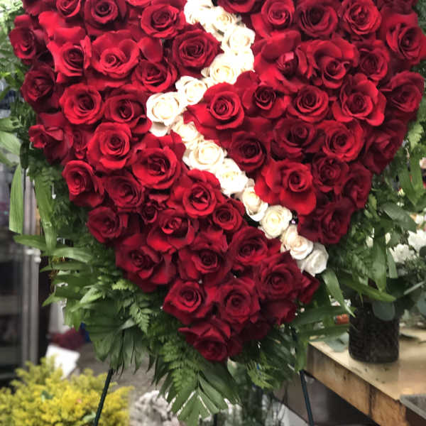 Heart-shaped rose arrangement with red and white roses