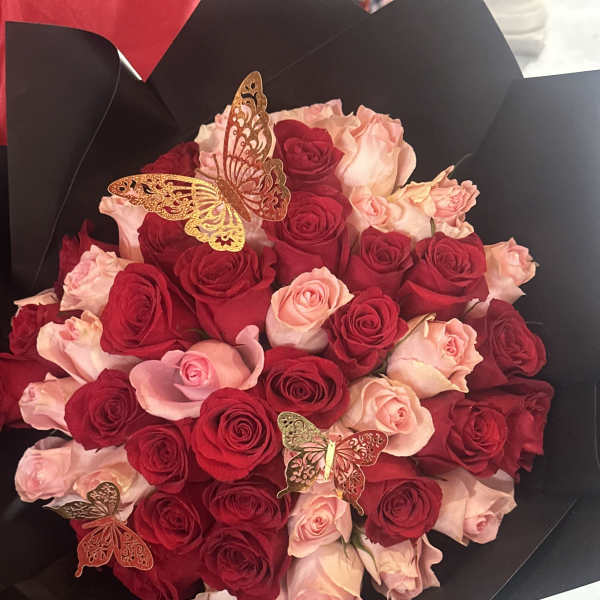 Bouquet of red and pale pink roses with butterfly decorations