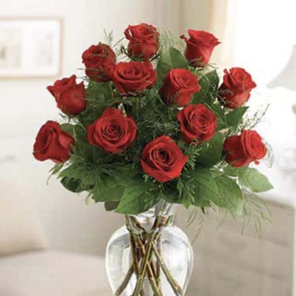 Red roses arranged in a clear glass vase