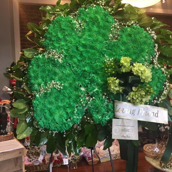 Large green floral standing spray with a "Loving Friend" ribbon