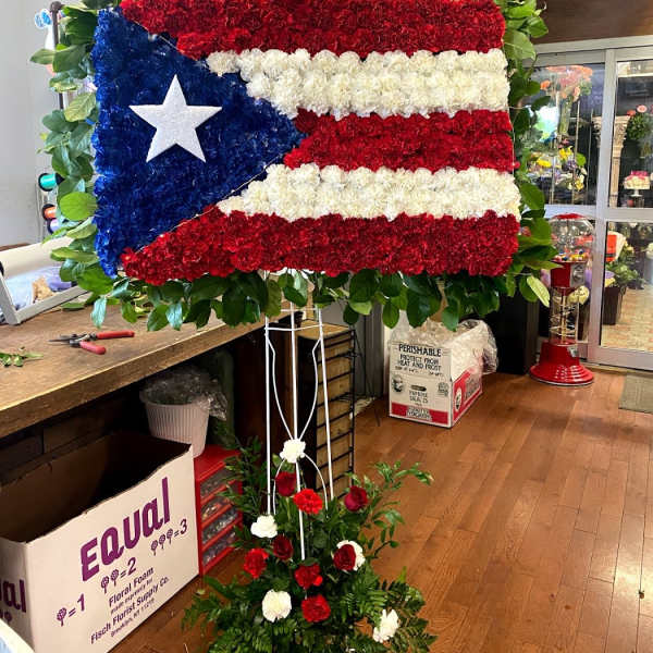 Large floral display shaped like the Puerto Rican flag on a stand