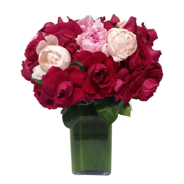Bouquet of red and pale pink roses in a green glass vase