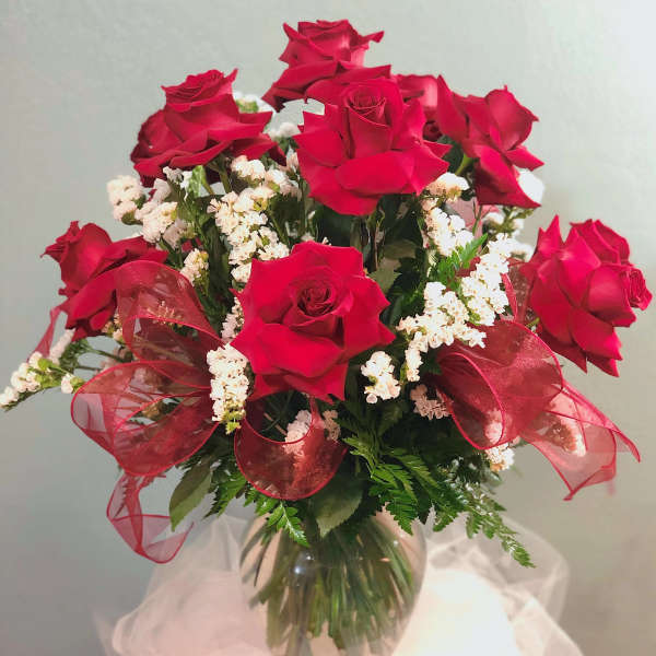 Bouquet of red roses with white filler flowers in a glass vase