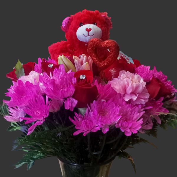 Pink and red bouquet with a teddy bear and heart in a glass vase