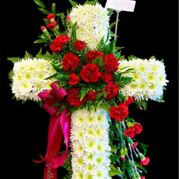 Cross-shaped floral tribute with white chrysanthemums and red carnations