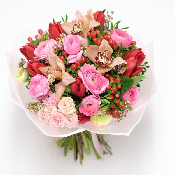 Bouquet of pink and red flowers wrapped in white paper