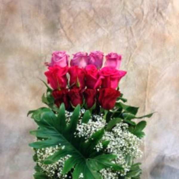 Tall bouquet of red and pink roses with white filler flowers