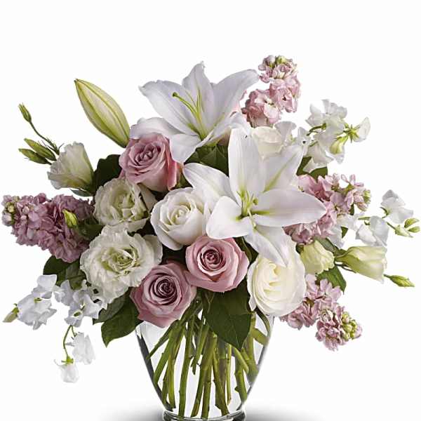 Pink and white bouquet with lilies and roses in a glass vase