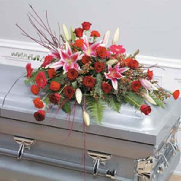Red and pink floral spray on a silver casket