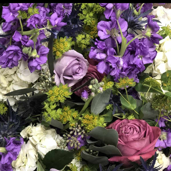 Purple and white floral bouquet with roses and spiky blue flowers