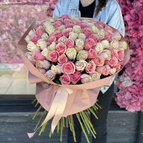 Large bouquet of pink and white roses wrapped in blush paper