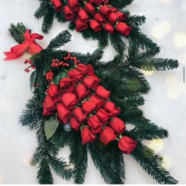 Red rose bouquets with evergreen branches and ribbon