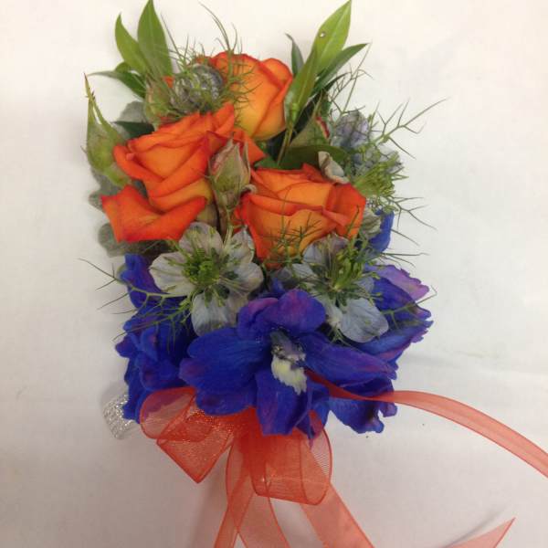 Orange roses with blue flowers and a ribbon bow